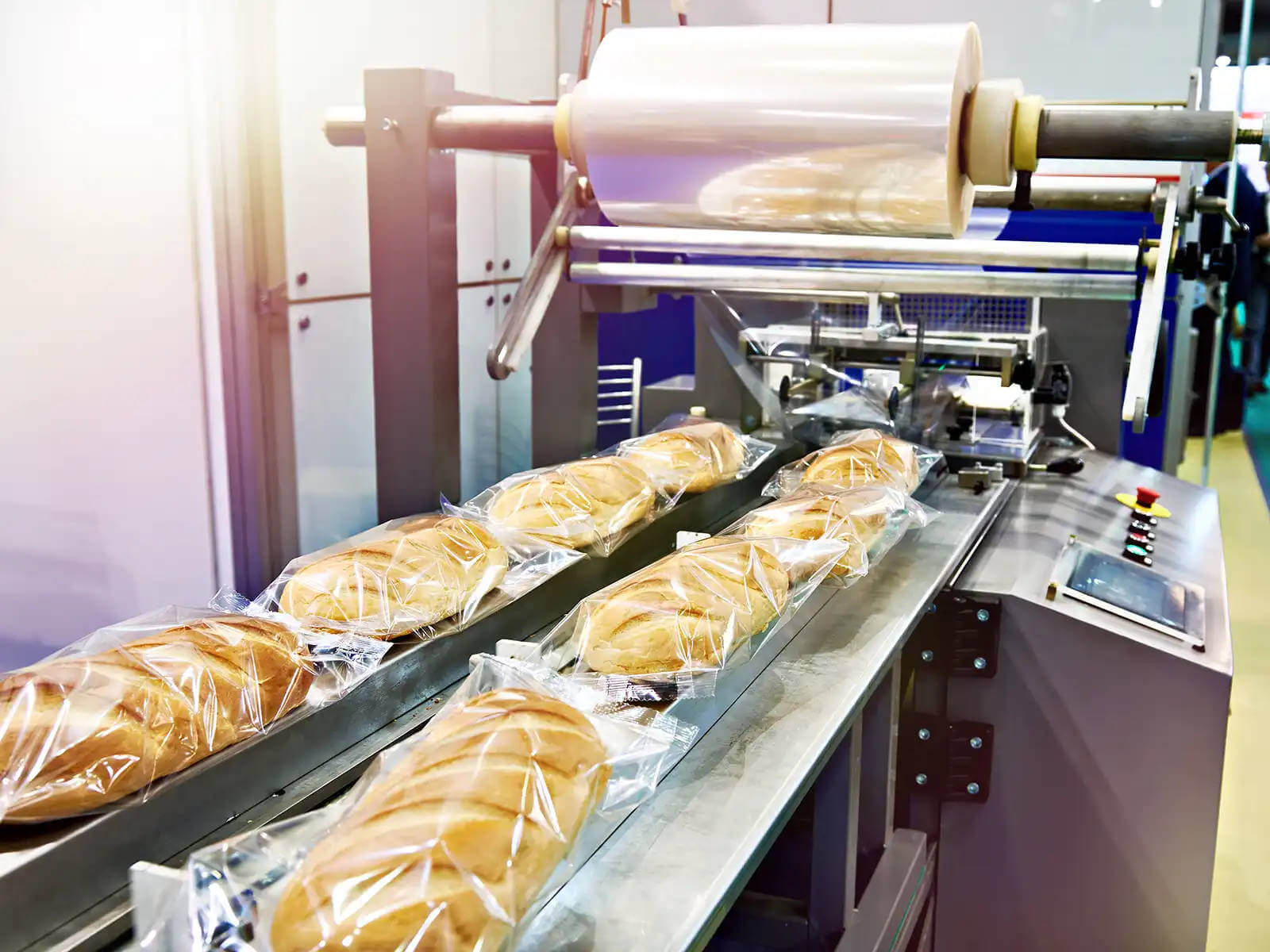 Becsomagolt kenyerek haladnak végig a gyártósoron.